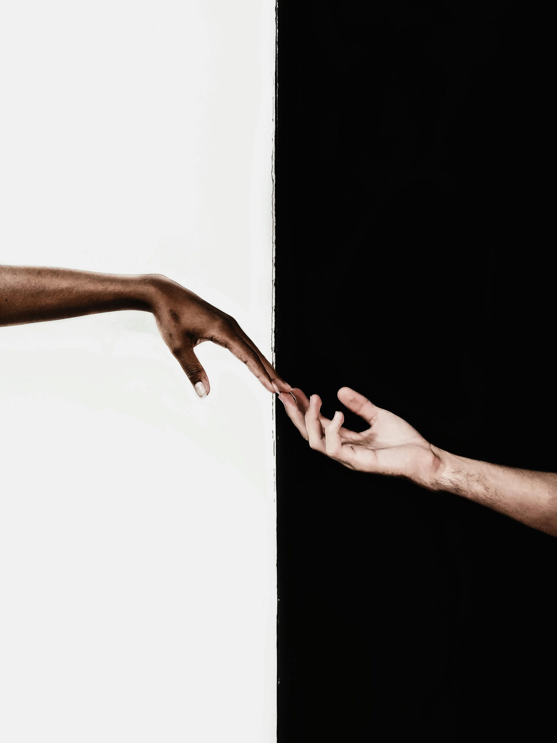 two- hands- reaching- out- to -each- other- across -a black- and -white- background,-
