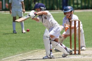 "Teacher- coaching -children- in -cricket-