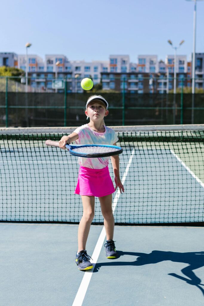 Teacher -coaching -children- in- shuttle -badminton- guiding-